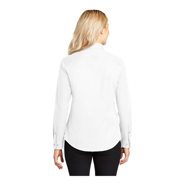 A woman wearing a white Port Authority long sleeve dress shirt.