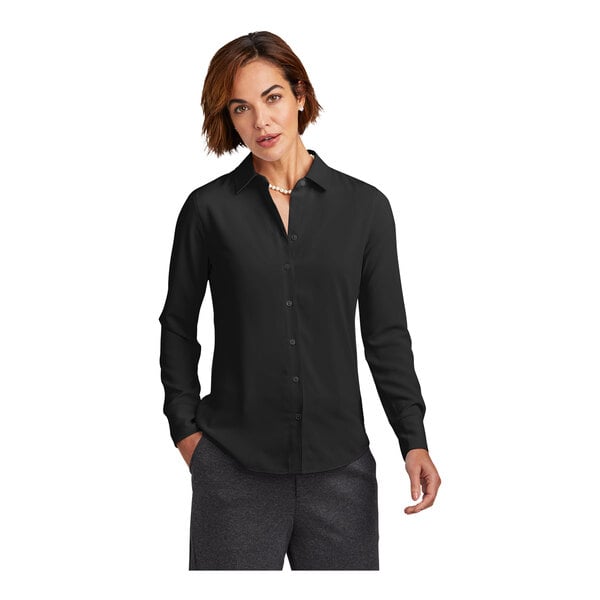 A woman wearing a Brooks Brothers deep black long sleeve full-button satin blouse.