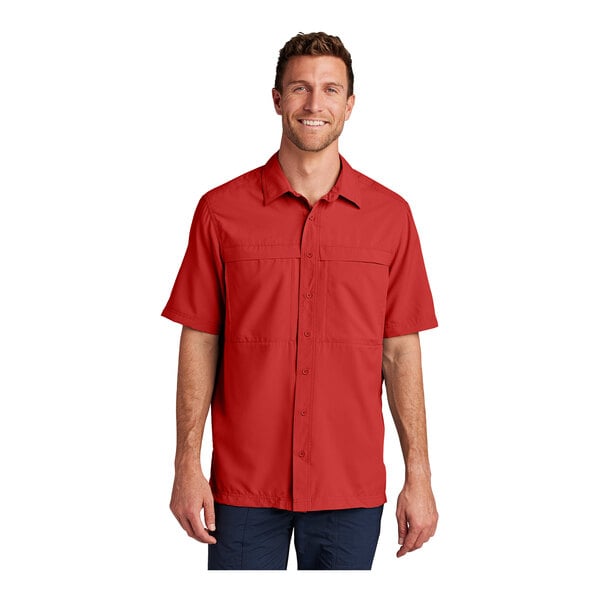 A man wearing a Port Authority rich red short sleeve shirt.