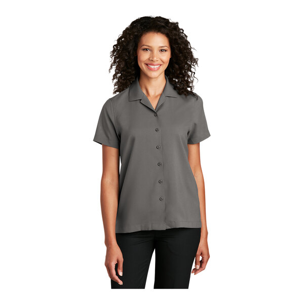 A woman wearing a graphite Port Authority staff shirt with short sleeves.