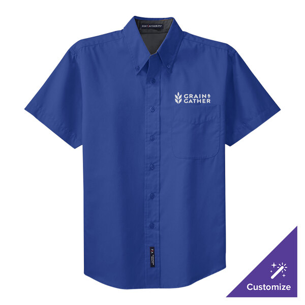 A medium unisex Port Authority short sleeve dress shirt in royal blue with a logo.