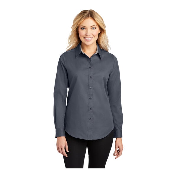 A woman wearing a Port Authority steel gray and light stone long sleeve poplin dress shirt.