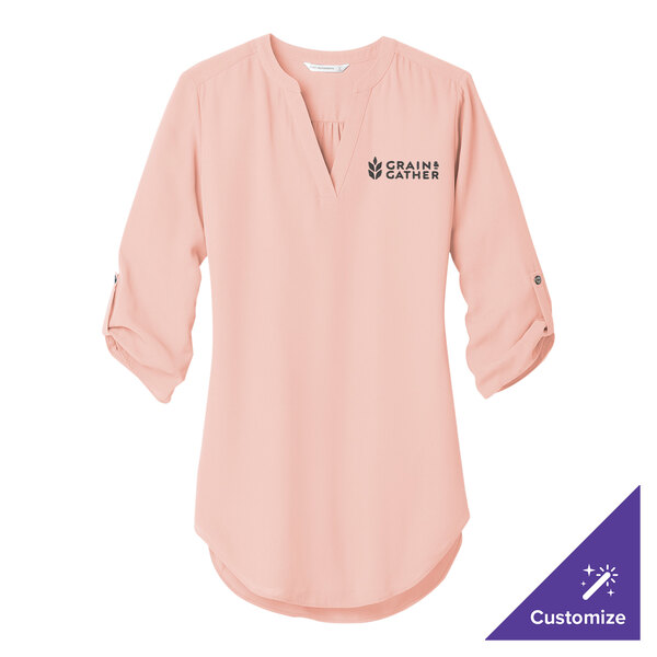 A pink Port Authority tunic blouse with white text on the front.