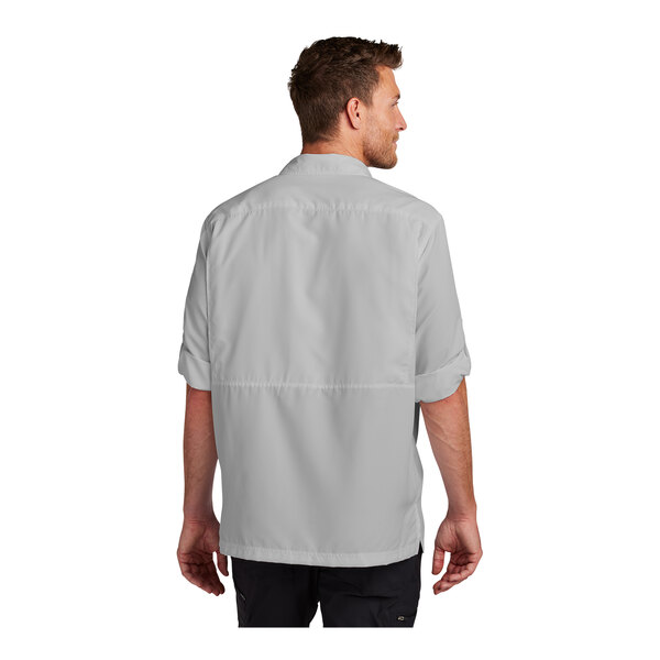 A man wearing a grey Port Authority long sleeve shirt.