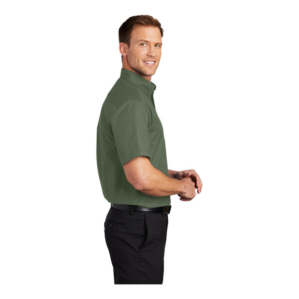 A man wearing a clover green Port Authority short sleeve dress shirt.