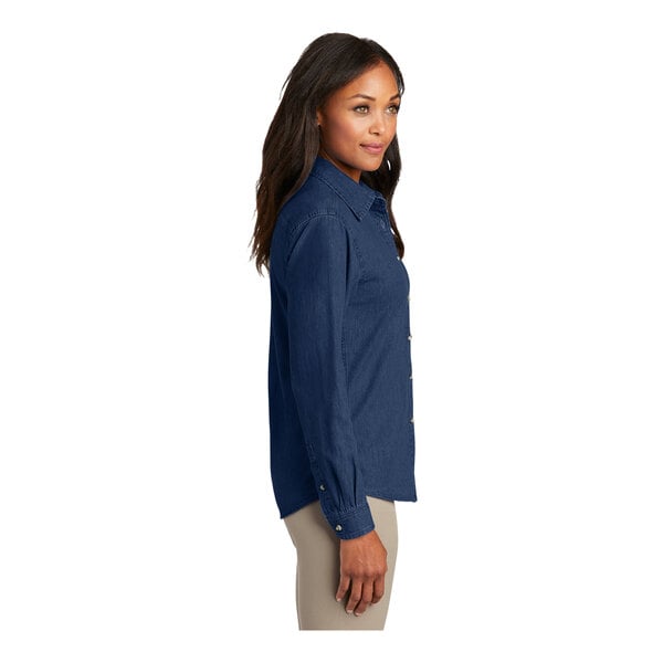 A woman wearing an ink blue Port & Company short sleeve button-down shirt.