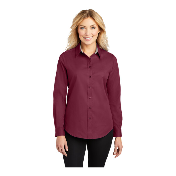 A woman wearing a Port Authority burgundy long sleeve dress shirt.