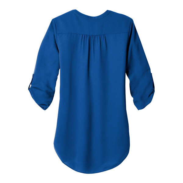 A back view of a blue Port Authority short sleeve blouse with a ruffle on the back.