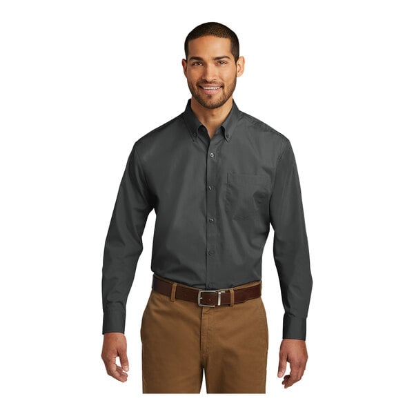 A man wearing a Port Authority graphite long sleeve poplin shirt.