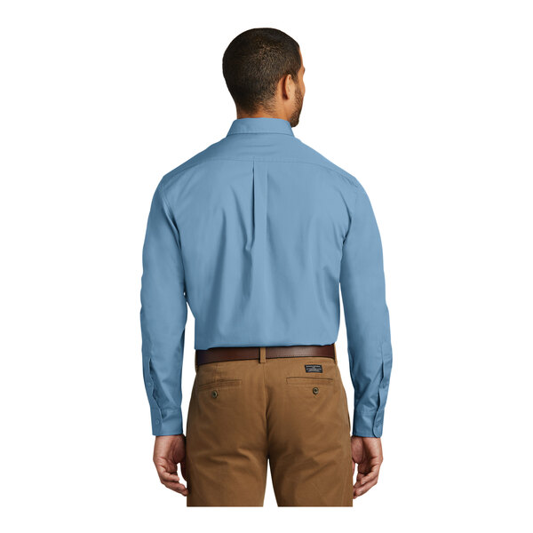 A man wearing a Port Authority Carolina blue long sleeve poplin dress shirt.