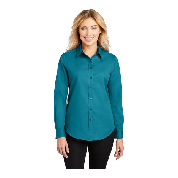 A woman wearing a Port Authority teal green long sleeve dress shirt.