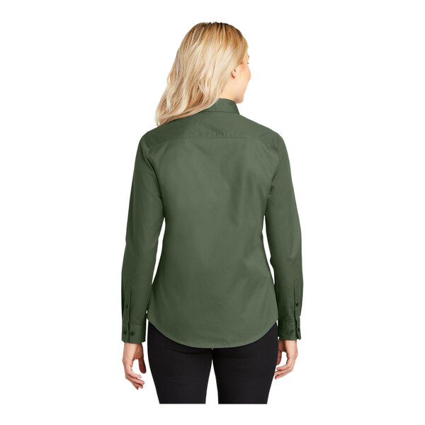 A woman wearing a Port Authority clover green long sleeve dress shirt.