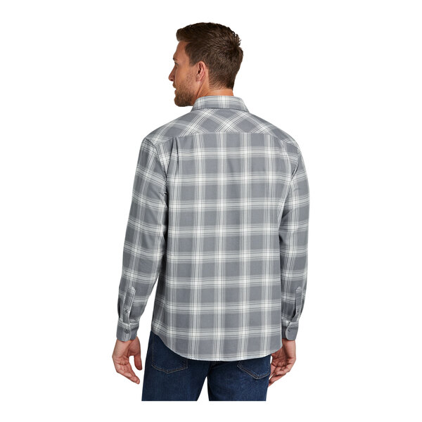 A man wearing a gray and cream plaid Port Authority flannel shirt.