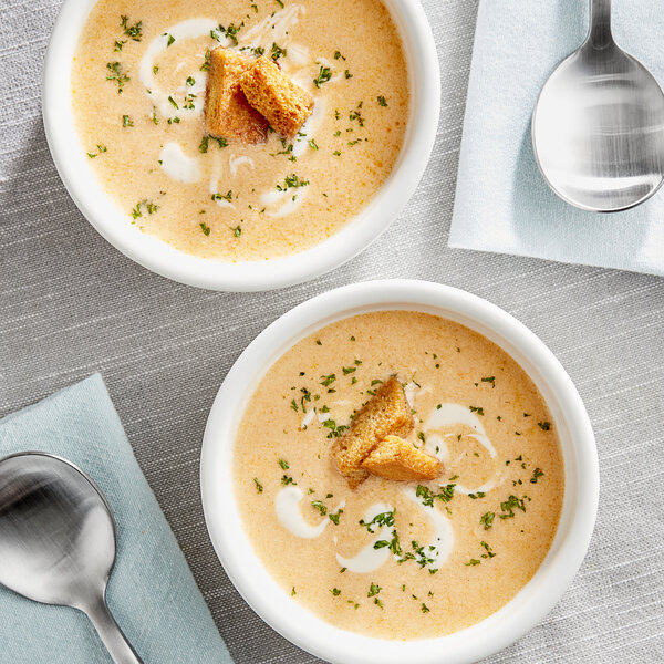 Two bowls of Blount Lobster Bisque with croutons and a spoon.