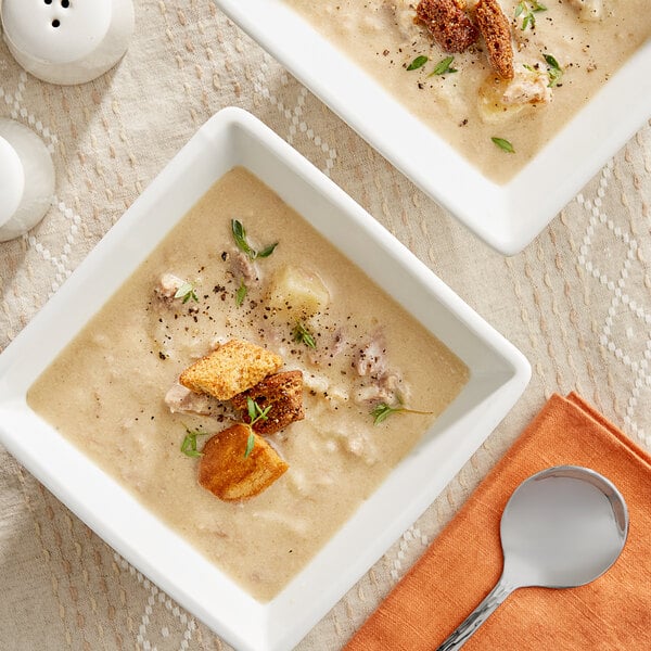 Two bowls of Blount Fine Foods Steak and Ale Chowder with croutons and herbs.