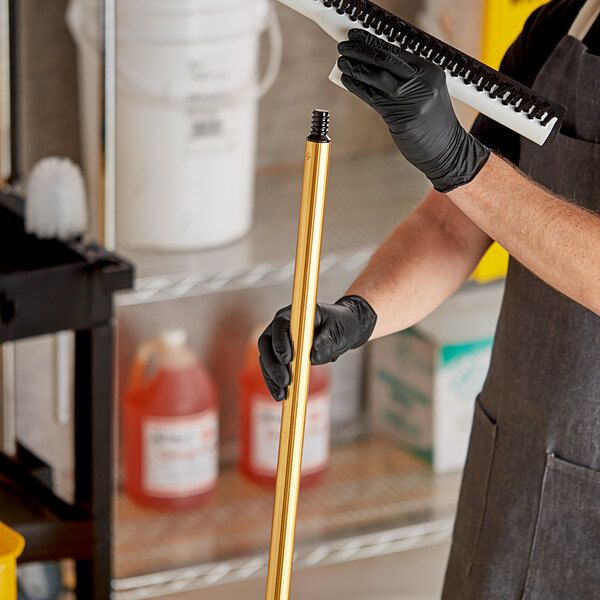 A person holding a tool with a threaded aluminum pole handle.