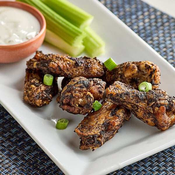 A plate of chicken wings and celery with Walkerswood Hot and Spicy Jerk Seasoning