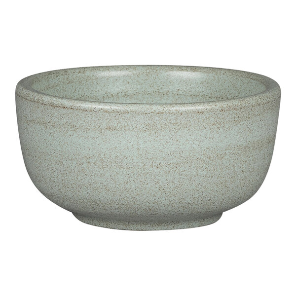 A close-up of a Rakstone Selva aqua green porcelain ramekin with a brown speckled design.