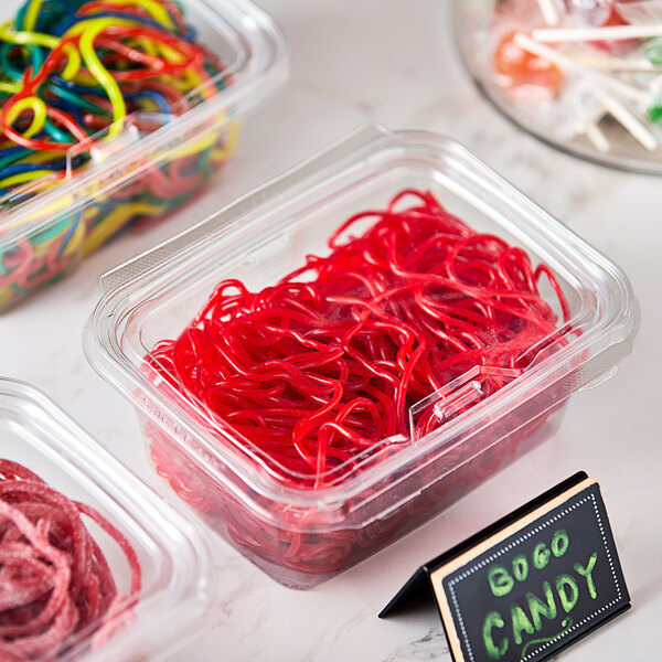 A plastic container of red licorice laces with a label for Gustaf's Strawberry Licorice.