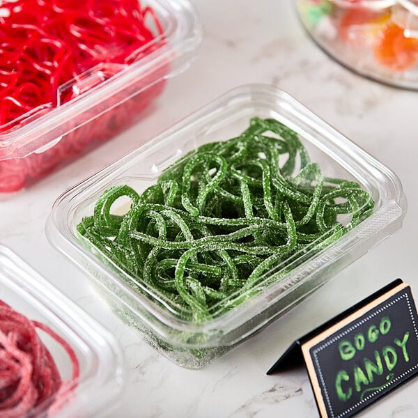 A plastic container of green Gustaf's sour apple licorice laces.