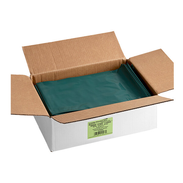 A cardboard box with green plastic bags inside.