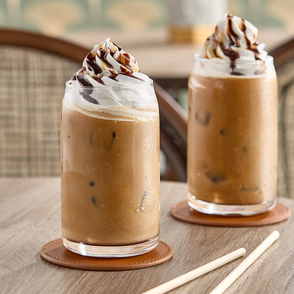 Two glasses of Dr. Smoothie Kona Mocha Coffee with whipped cream on top on a table.