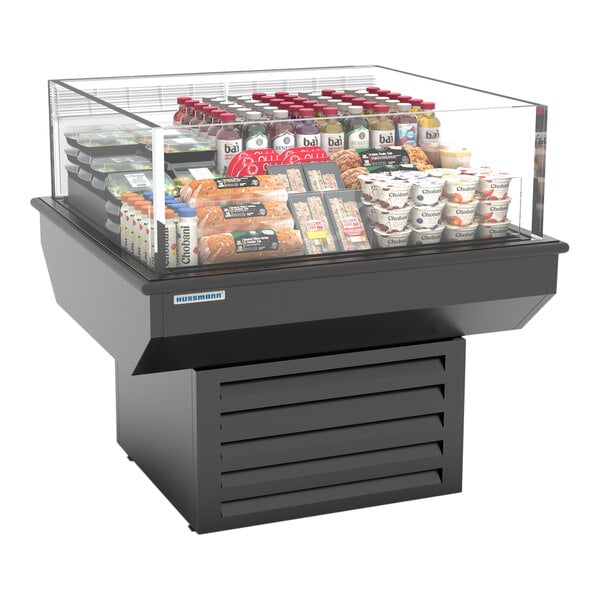 A black Hussmann mobile 4-sided island air curtain merchandiser with food inside.