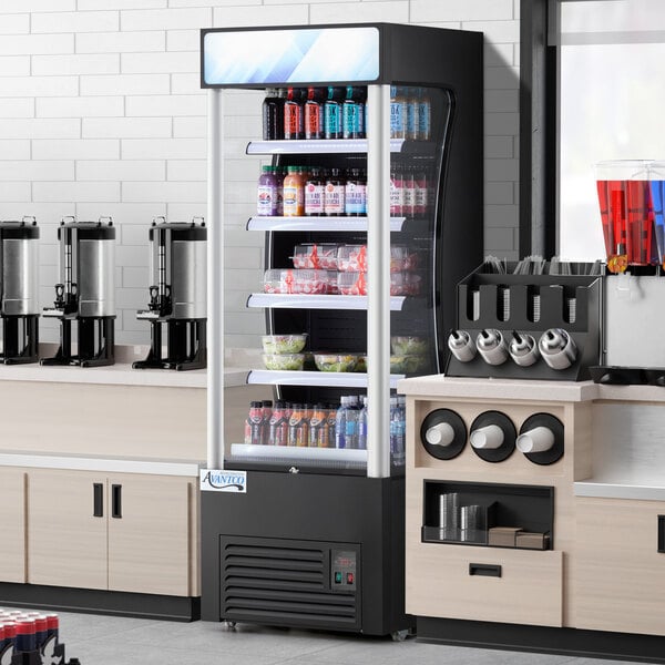 An Avantco black refrigerated air curtain merchandiser full of drinks on a counter.