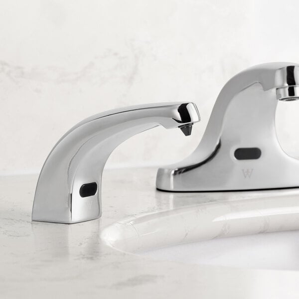 A Waterloo chrome automatic soap dispenser sitting on a white counter.