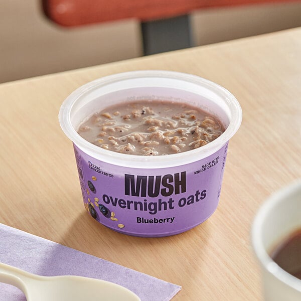 A cup of Oats Overnight Blueberry mush on a table.