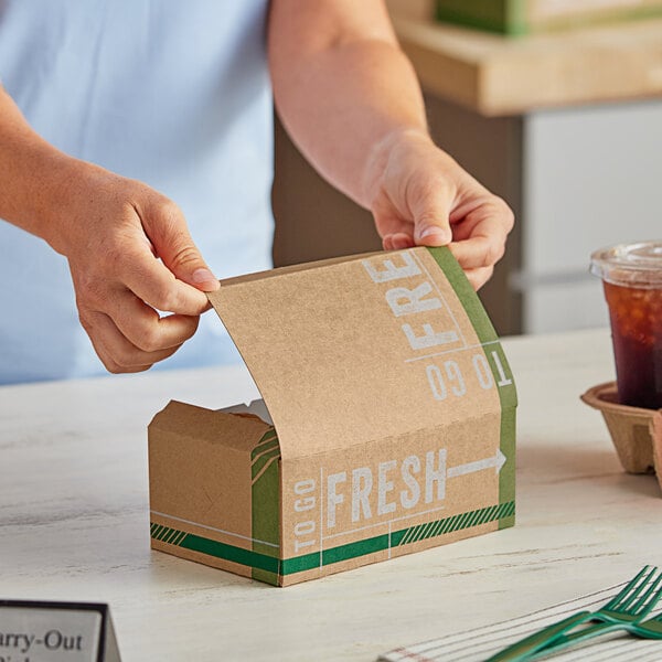 A person opening a Fresh Print chicken box on a counter.