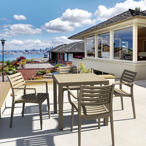 A Siesta Ares taupe table and chairs on an outdoor patio.