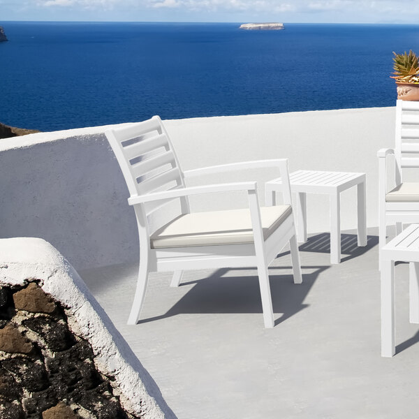 A white Siesta Artemis outdoor club arm chair and table.