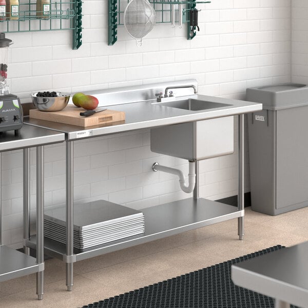 A Regency stainless steel work table with a sink on the right.