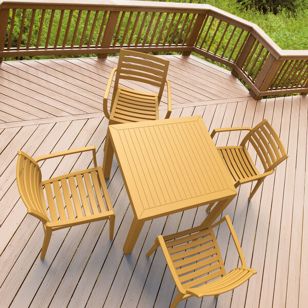 A Siesta Ares teak table and chairs on a deck.