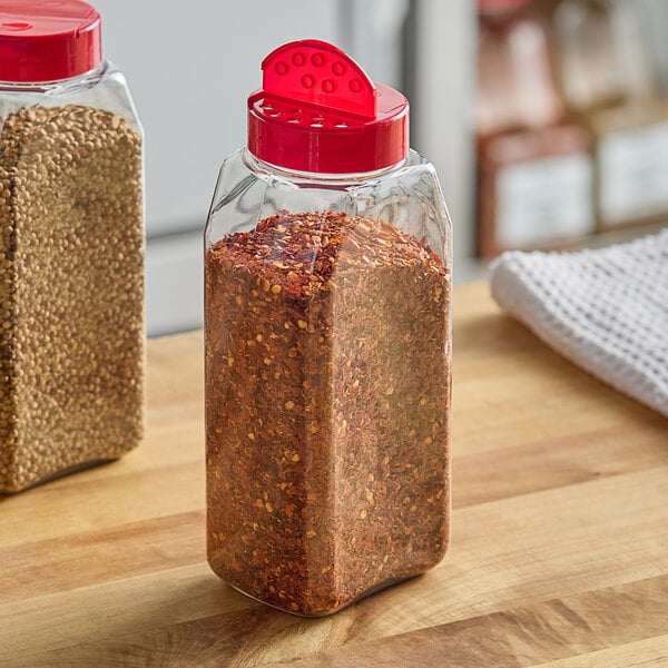 Two rectangular plastic spice containers filled with red spices.