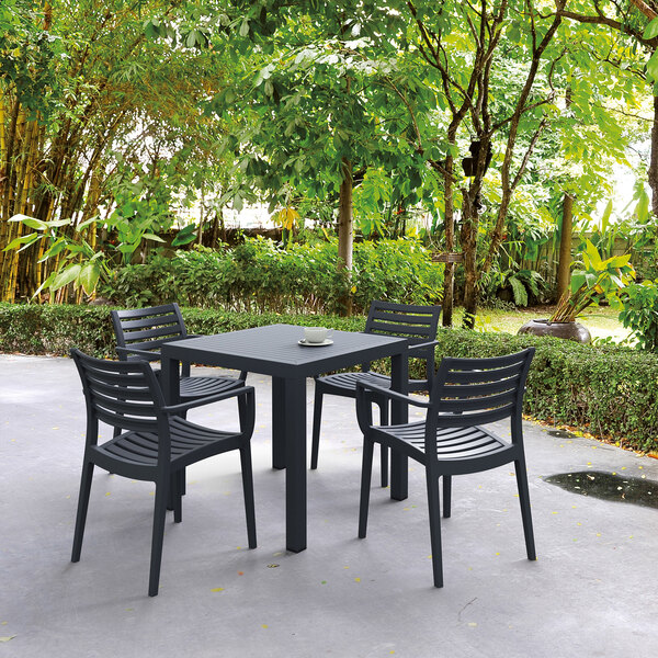 A Siesta Ares standard height table and chairs on a patio.