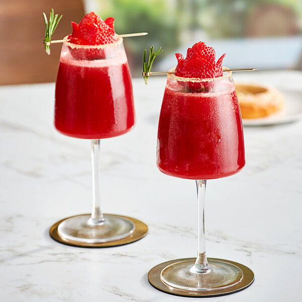 Two glasses of Andros Chef strawberry drink with strawberries and a sprig of rosemary.