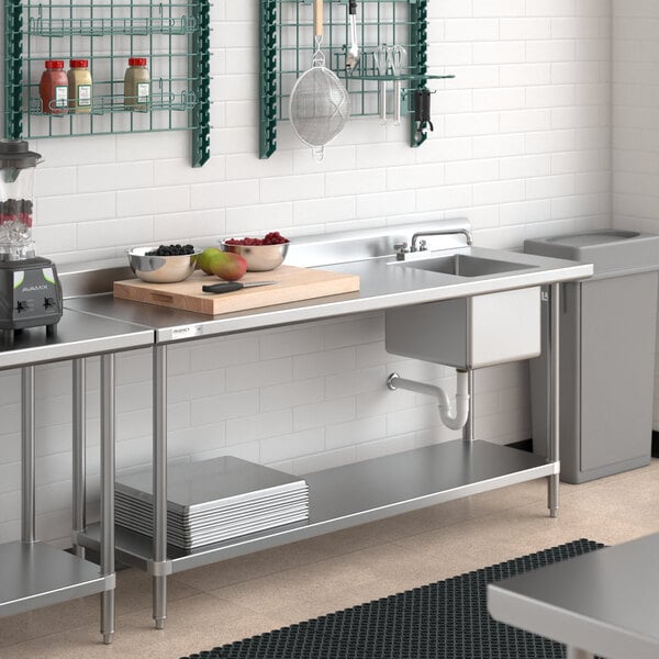 A Regency stainless steel work table with a sink on the right over a kitchen sink.