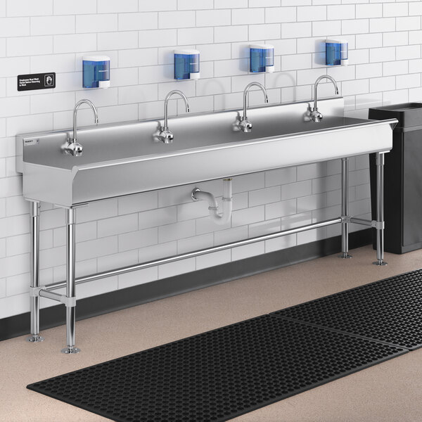 A Regency stainless steel hand sink with four Waterloo wall mount hands-free sensor faucets.