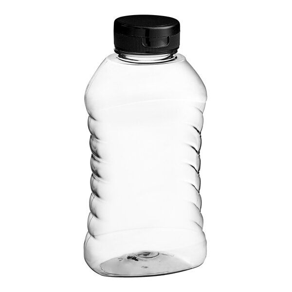 A clear plastic ribbed hourglass honey bottle with a black plastic flip top lid.
