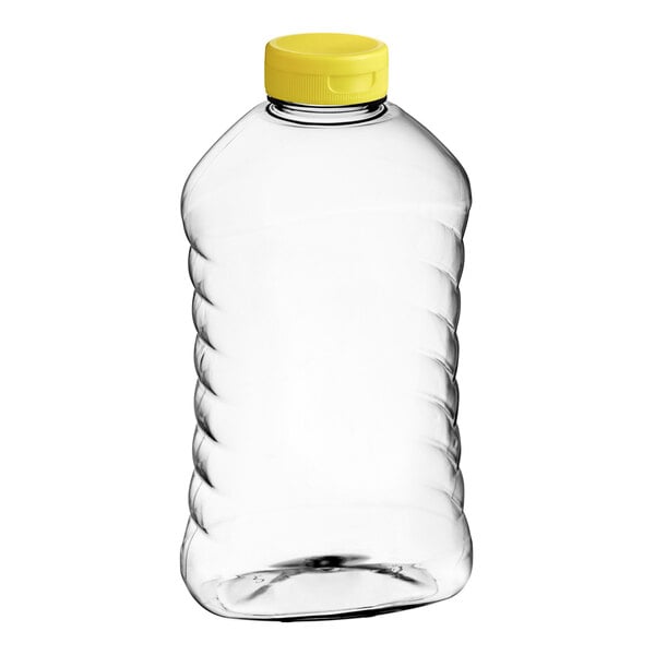 A clear plastic Ribbed Hourglass PET Honey bottle with a yellow flip top lid.