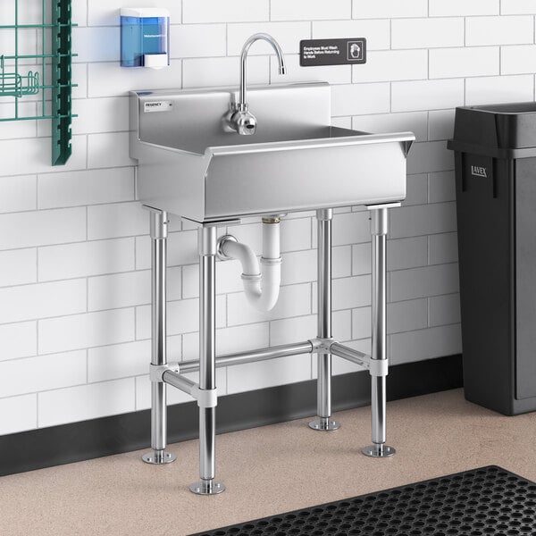 A stainless steel Regency hand sink with a Waterloo hands-free faucet above it.