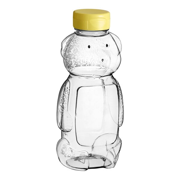 A clear plastic Bear Honey bottle with a yellow flip top lid.