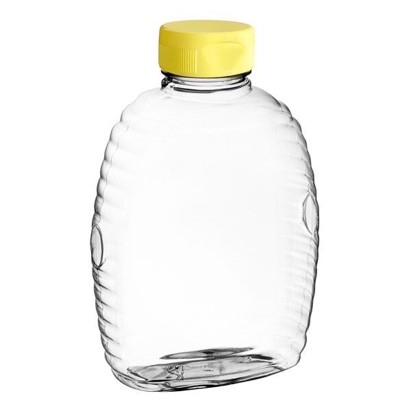 A clear plastic Queenline honey bottle with a yellow flip top lid.