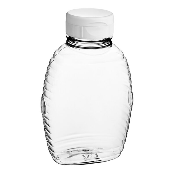 A clear plastic Queenline honey bottle with a white flip top lid.