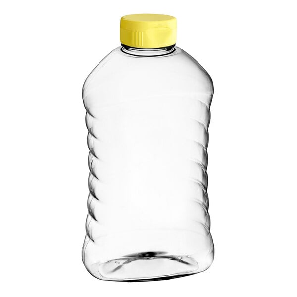 A clear ribbed PET honey bottle with a yellow cap.