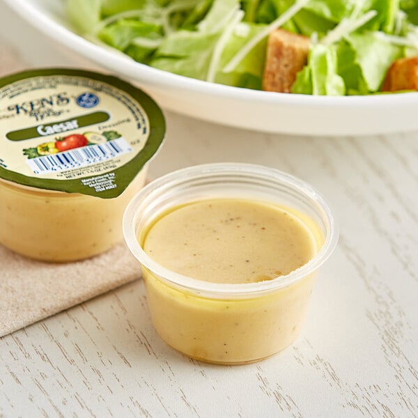 An open container of Ken's Foods Caesar Dressing.