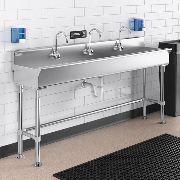 A stainless steel Regency hand sink with three Waterloo wall mount hands-free sensor faucets.