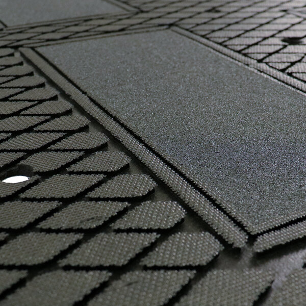A close up of a black Traction Tread Grit Mat with a square pattern.